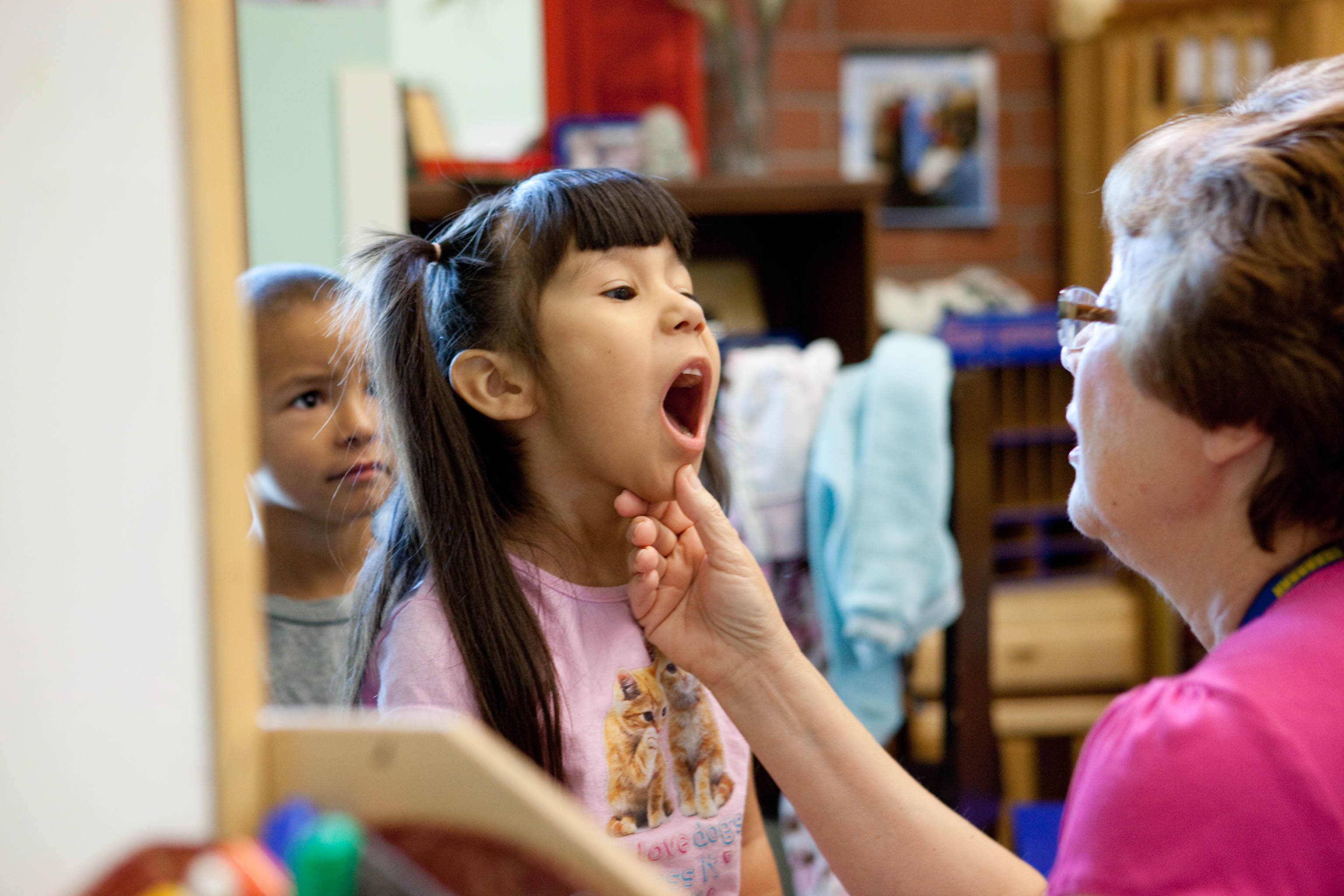 Niña abriendo bien la boca para que la doctora pueda revisarle las amígdalas.