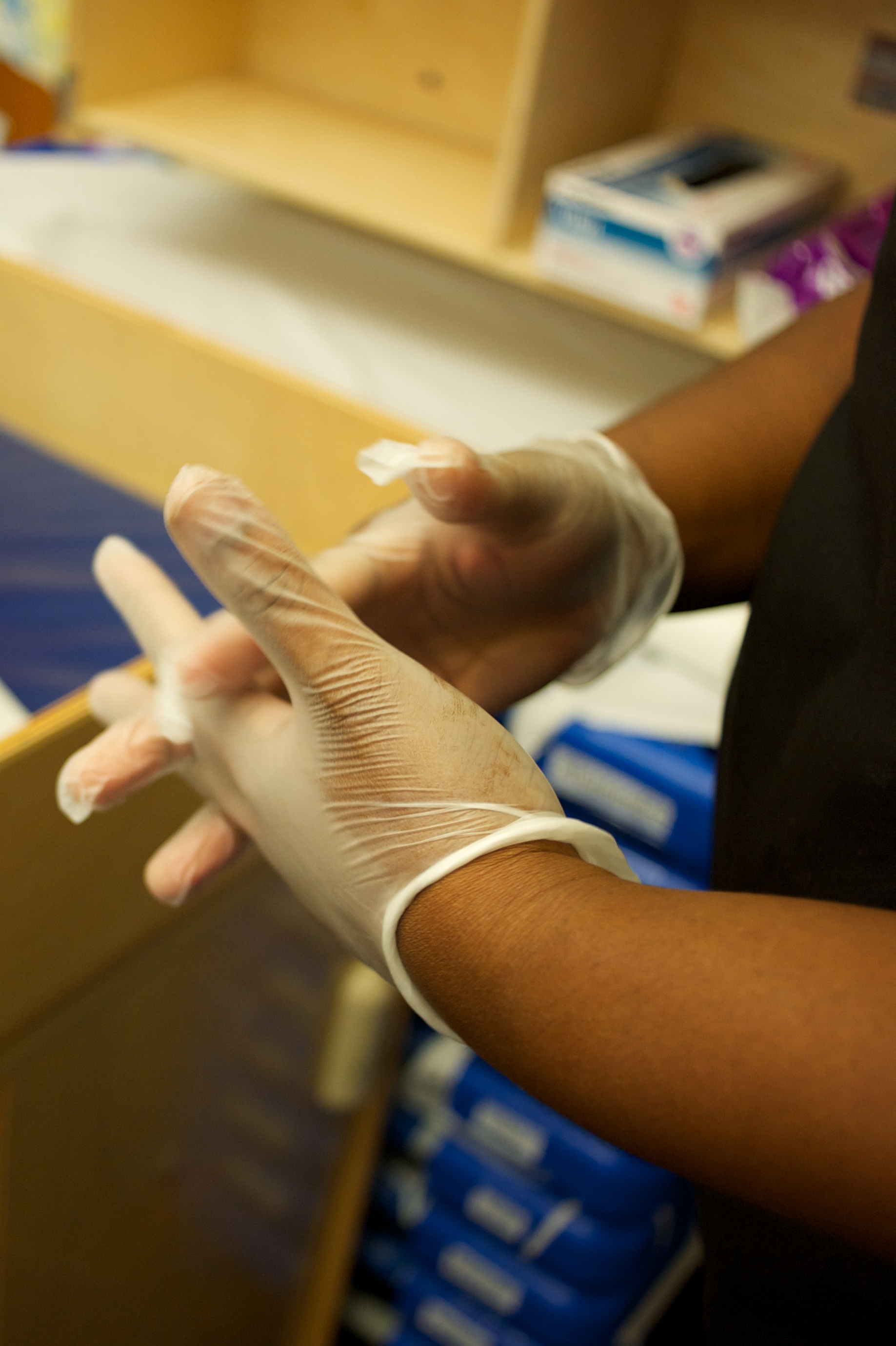 Primer plano de un miembro del personal con guantes de látex para protegerse.