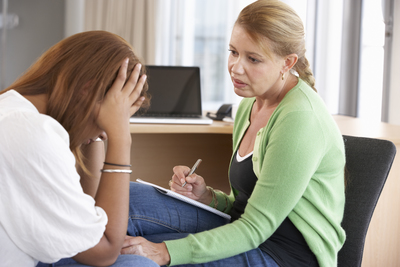 A health care worker consoling a depressed woman.