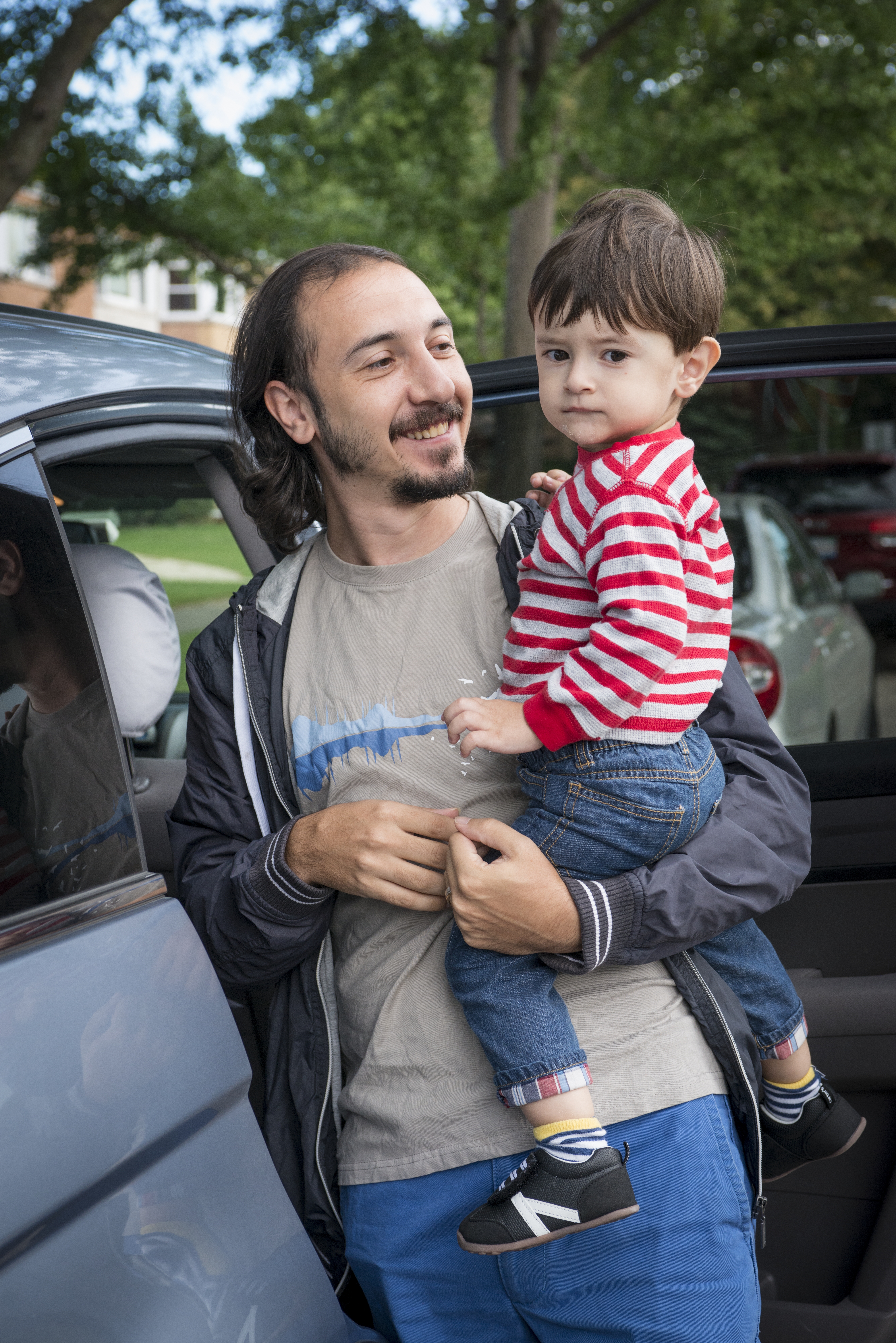 Padre sostiene a su hijo pequeño al nivel de la cara.