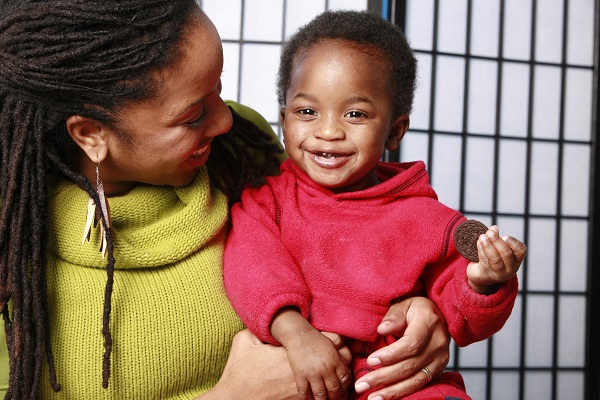 Mother smiling to her young child.