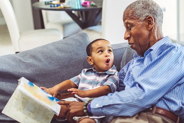 Grandfather reading to his grandchild.