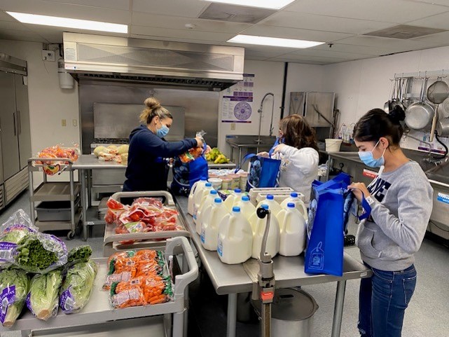 Staff assembling food bags for delivery