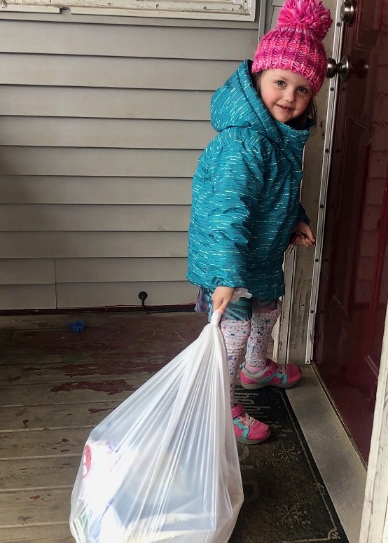 Niña cargando una bolsa de comestibles