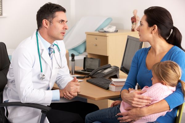 Doctor talking to parent with child.