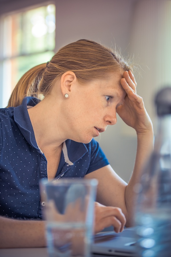 Exhausted woman with her hand on her forehead