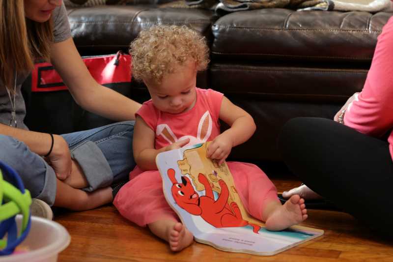 Baby playing with a children's book.