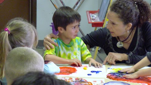 A teacher reassuring an upset young boy.