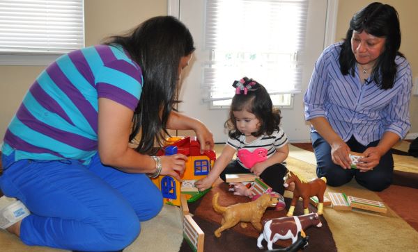 Child playing with a toy farm and animals.