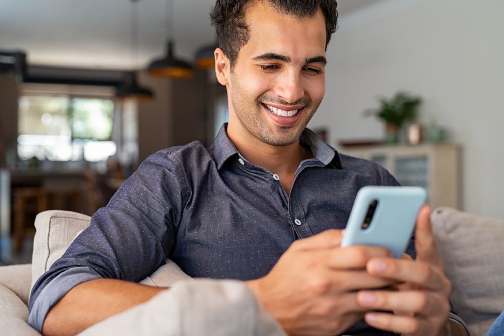 Un hombre usando su teléfono inteligente para hacer reuniones virtuales.