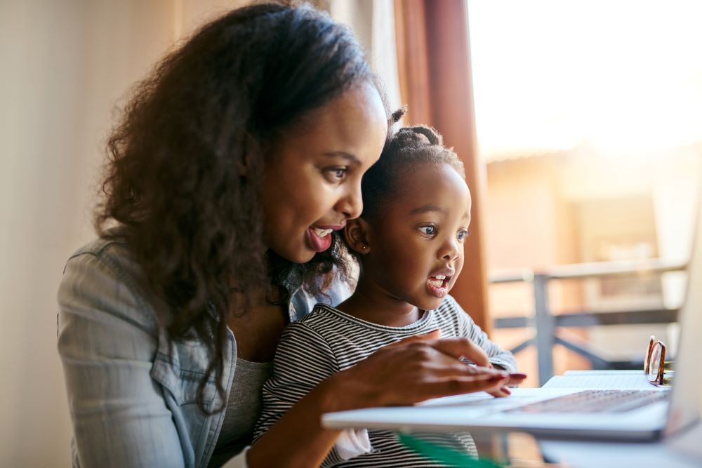 Mother and daughter at the computer on a virtual call.