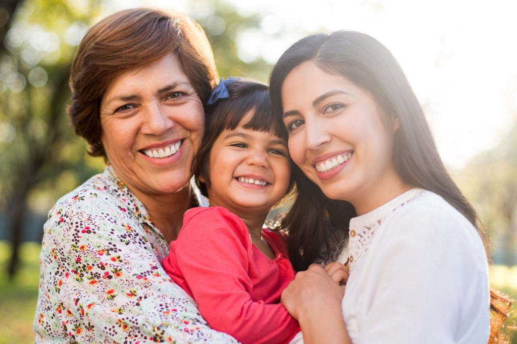 Three generations of woman: grandmother, mother and daughter all posing together.