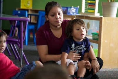 Maestra con niño pequeño en su regazo.