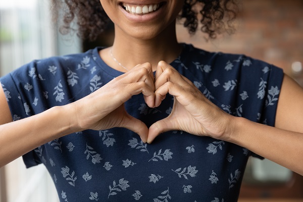 Woman shaping a heart outline with her hands.