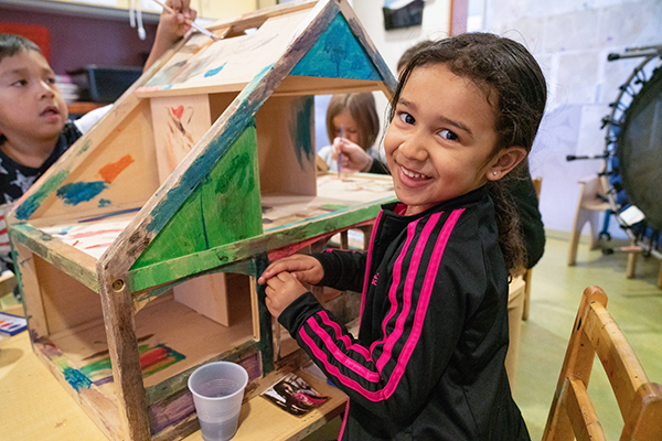 Child building a wooden house.