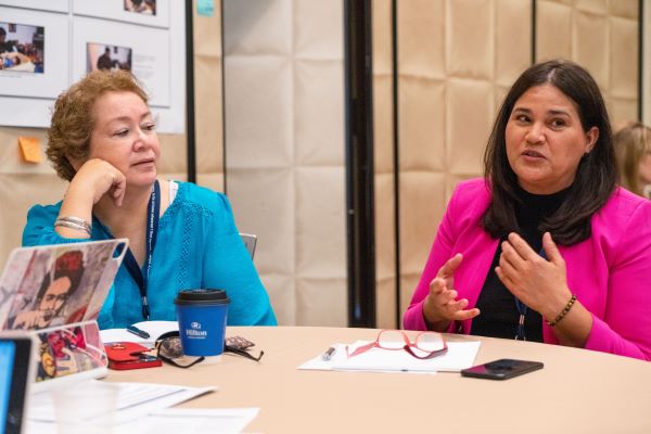 Two women at a table having a discussion.