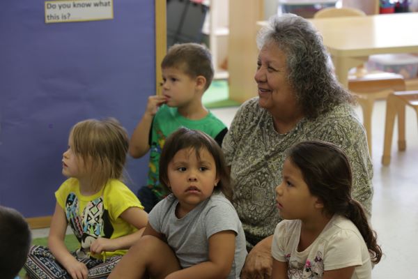 Daycare staff sitting with children.