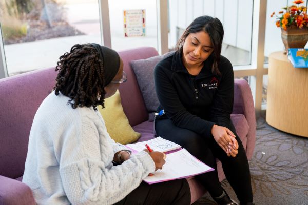 Teacher talking with a parent while seated.