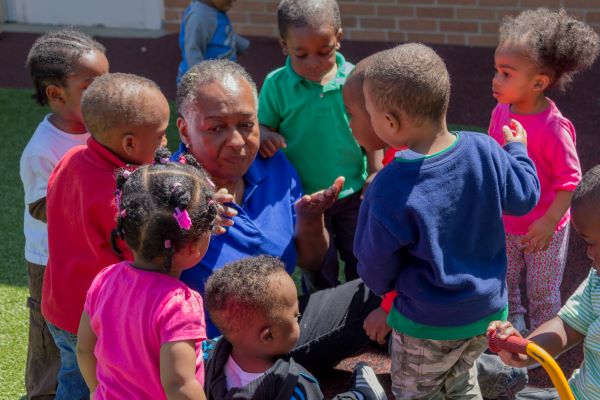 Several children gathered around their teacher.