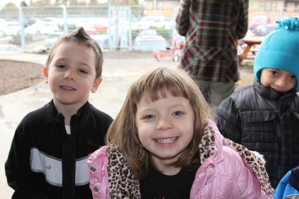 Smiling children wearing winter coats.