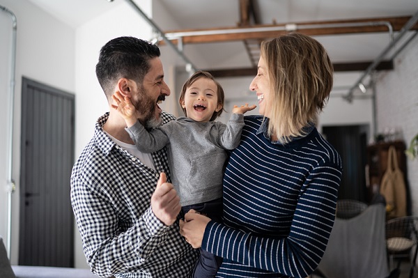 Happy mother and father holding up their child.