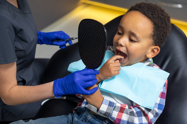 Young boy having his teeth examined by dental staff.