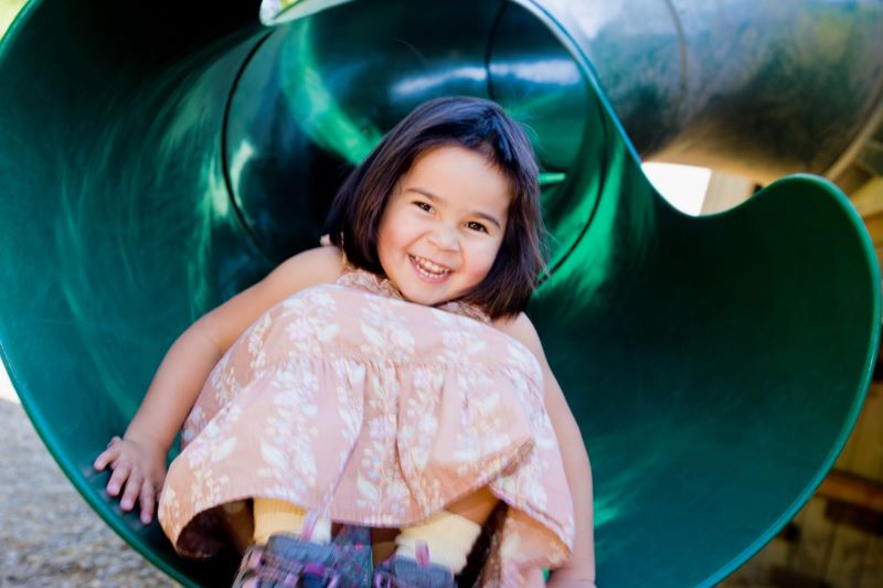 Young girl coming down from the slide.