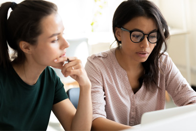 Two women looking at a computer screen.