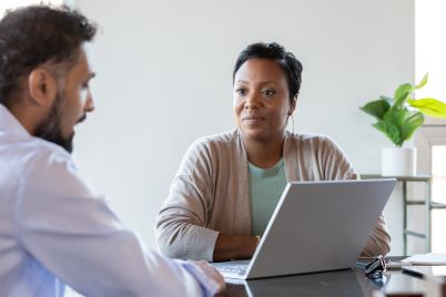 A man and woman in front of a computer screen.