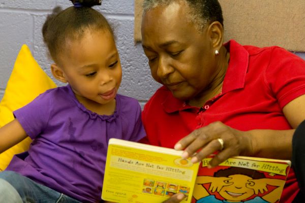 Adult and child reading together.