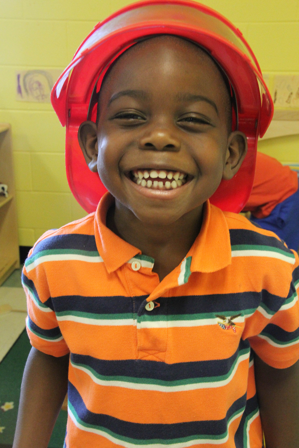 Young boy wearing a toy helmet.