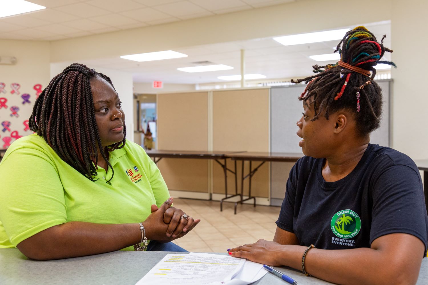 Two Head Start staff members sitting at a table going over paperwork.