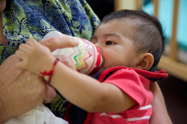 Infant being bottle fed.