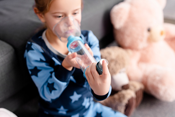 Niño respirando con una medicación respiratoria.