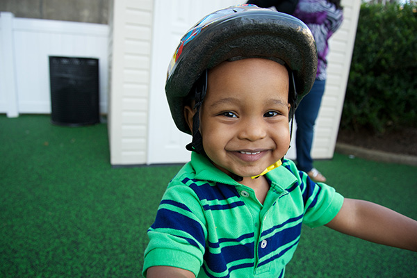 Niño con casco jugando al aire libre.