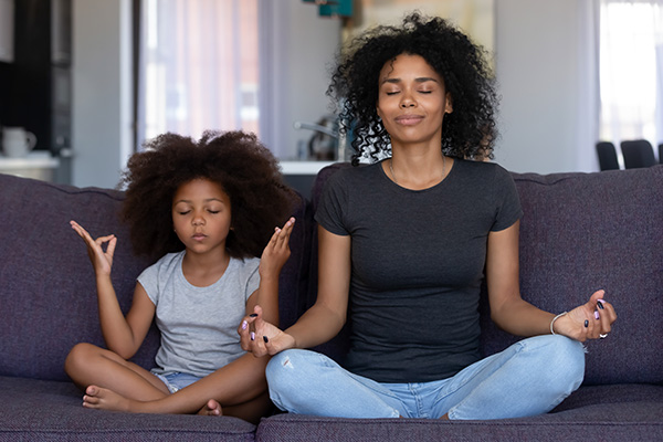 Mujer y niña practicando meditación.