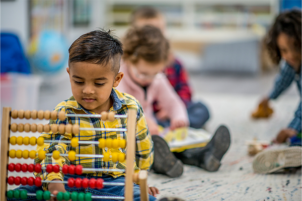 Preschool child using an abacus.