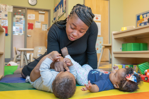 Maestra interactuando con dos niños pequeños