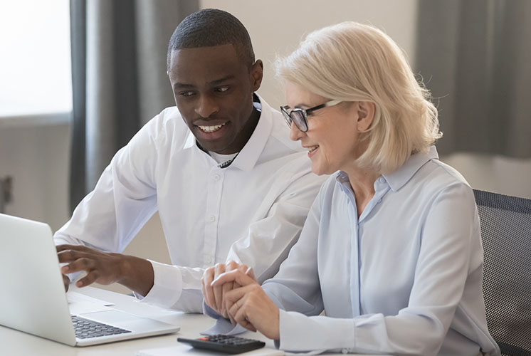 Coworkers looking into a laptop