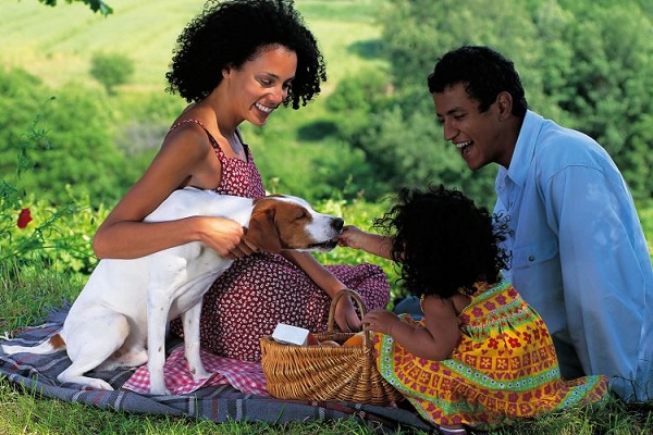 Familia disfrutando de un picnic en un parque.