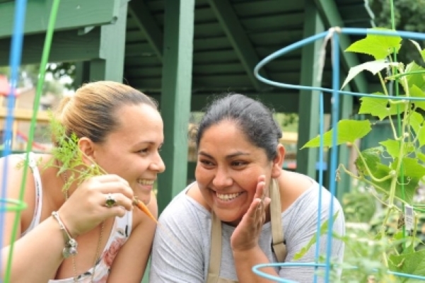 Two women talking while working on a neighborhood's garden.