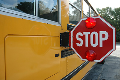 Bus displaying the stop sign extended.