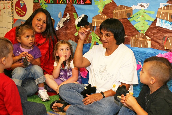 Native American woman talking with children in a classroom about cultural traditions