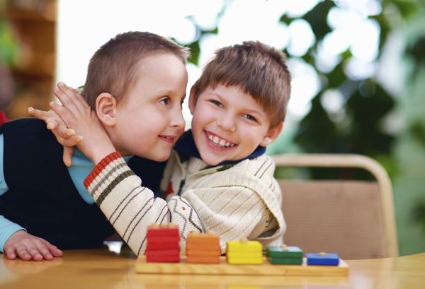 Two young children hugging each other.