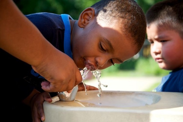 Child drinking water from a fountain.