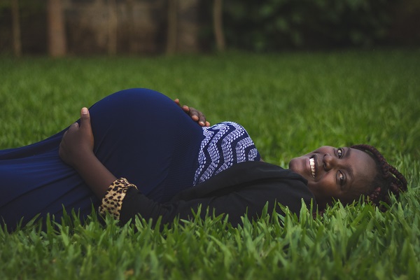 Pregnant woman laying on the lawn.