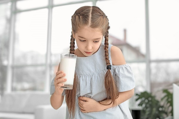 Child feeling pain when drinking a glass of milk.