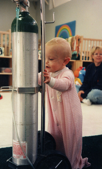 Baby using an oxygen tank