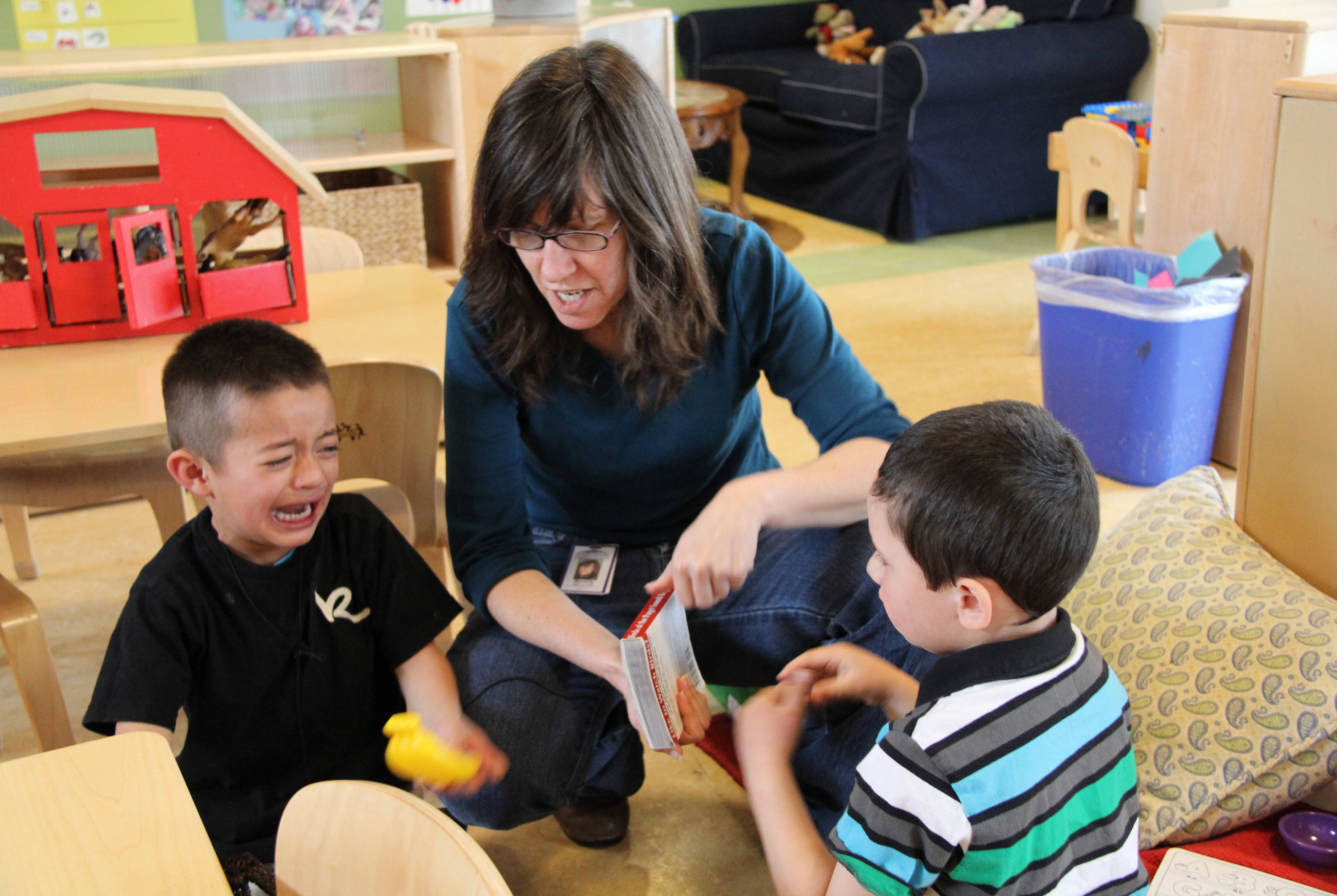 a teacher assists two boys who are upset