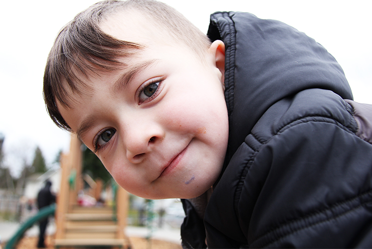 A boy looking directly into the camera, smiling